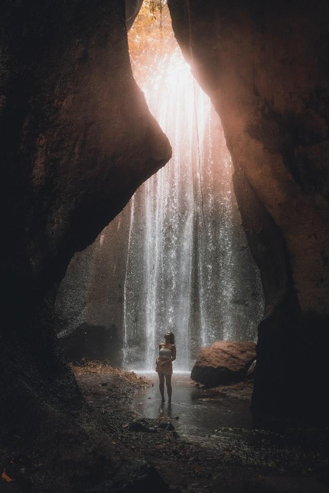 mujer bajo una cascada en bali, indonesia