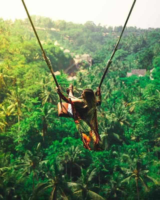 Mujer de columpio en Bali con vistas a los bosques