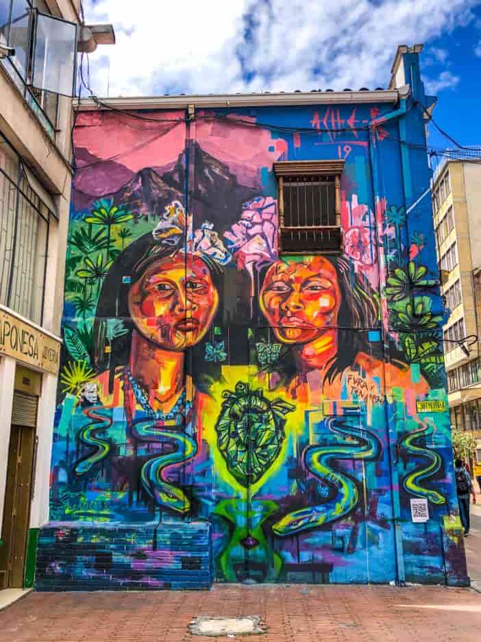 Rainbow graffiti art de dos mujeres en el lateral de un edificio en Bogotá Colombia