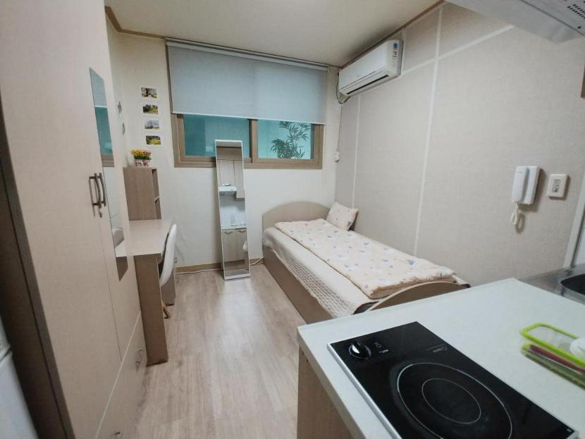 goshiwon pequeña habitación con cama, armario y cocina