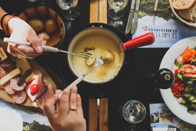 Gente compartiendo una fondu de queso